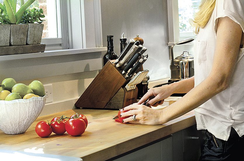 Butcher block countertops next to the stove is functional and over trash can