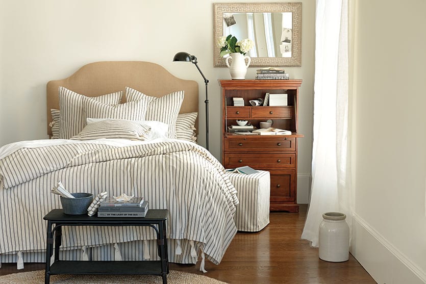 Ticking stripe bedding acts as a neutral in this bedroom