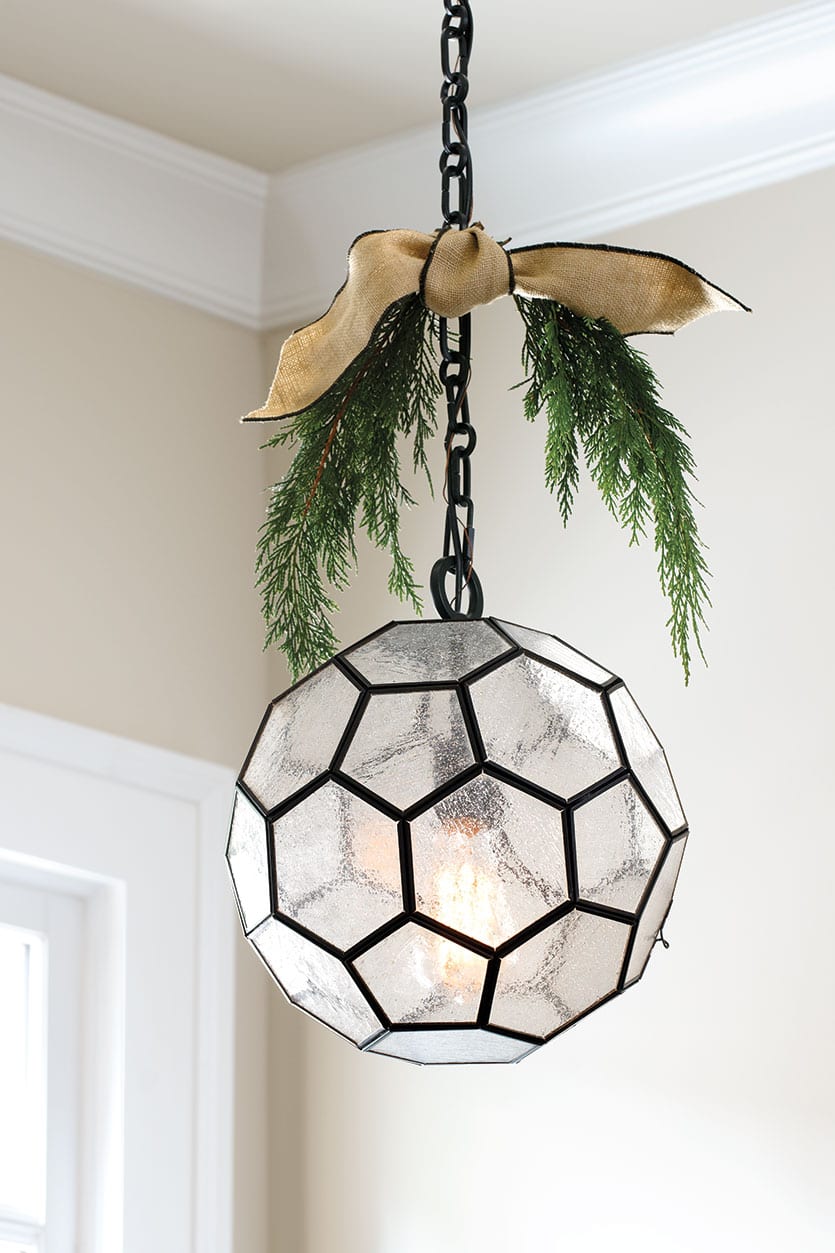 Pendant light with sprigs of greenery and ribbon