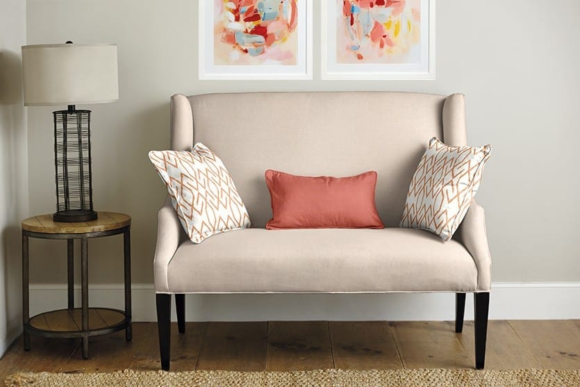 Blush and apricot fabrics on a loveseat