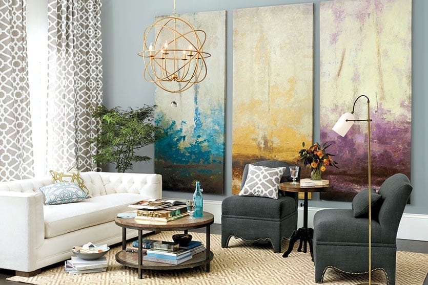 Use a series of paintings to fill a blank wall in a living room