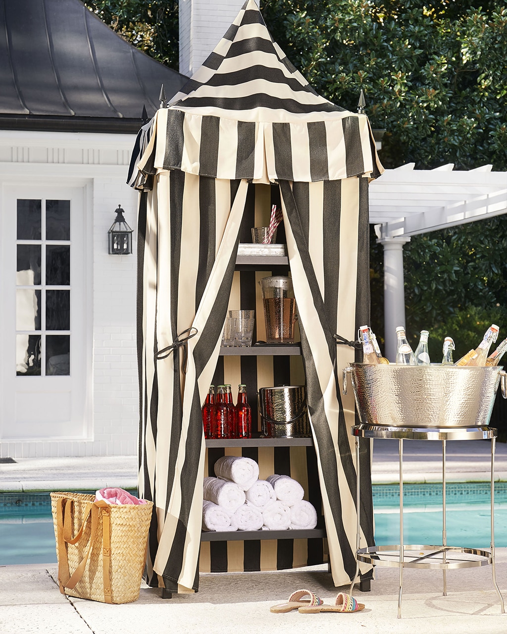 Black and white towel cabana from Ballard Designs next to pool