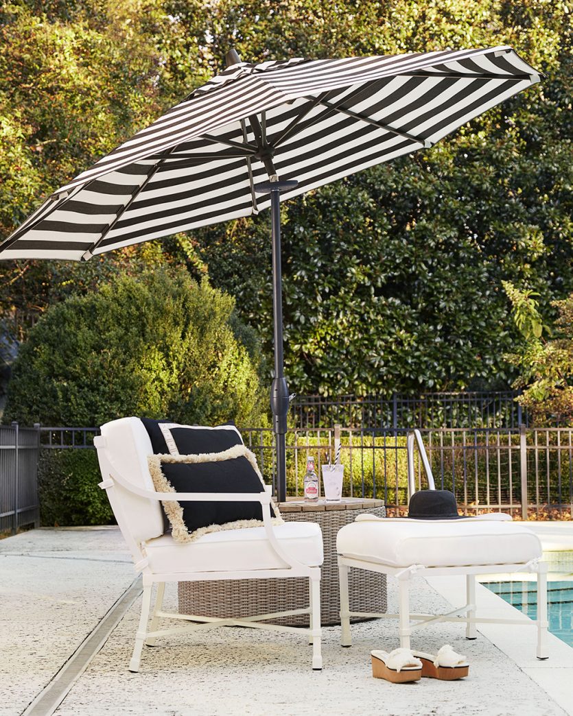 Black and white striped umbrella next to pool chair