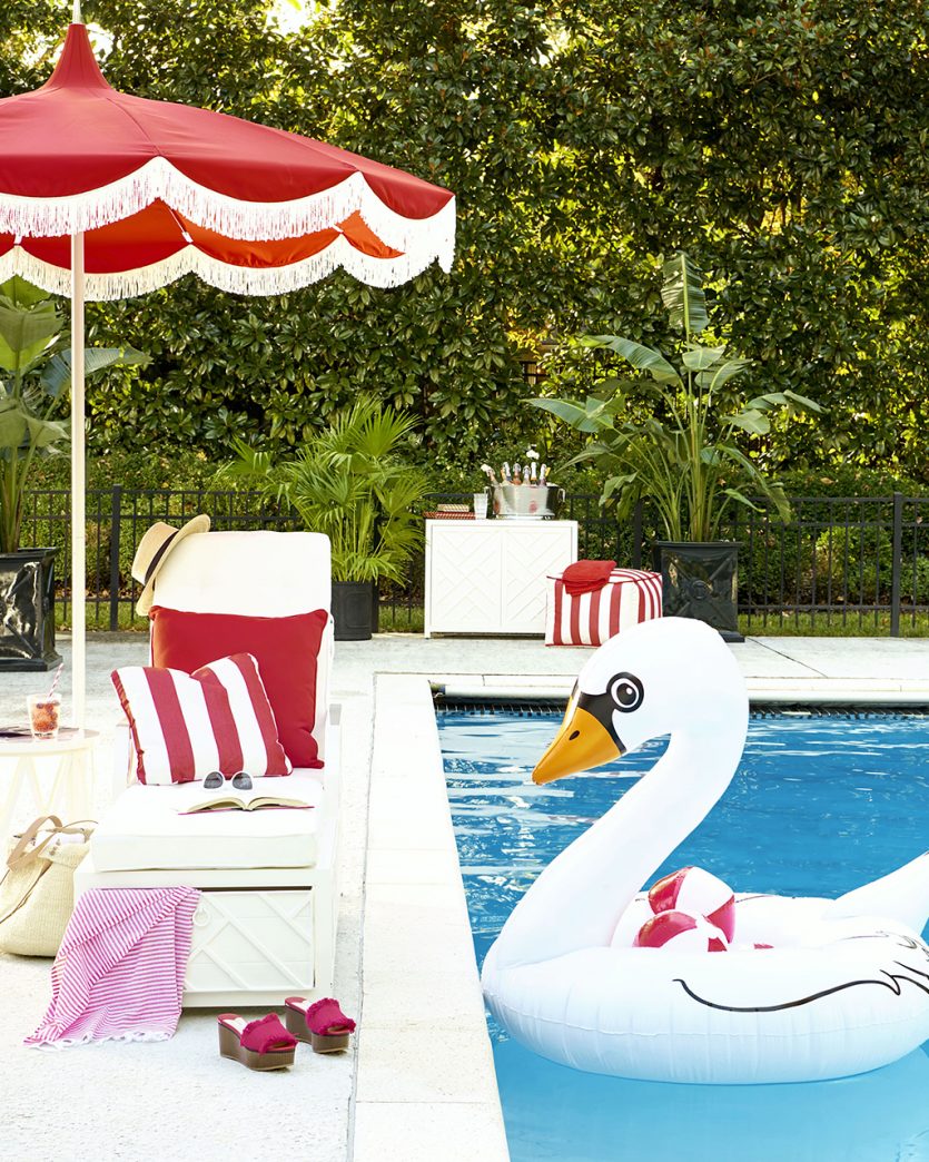 Red fringe pagoda umbrella over pool chaise lounge