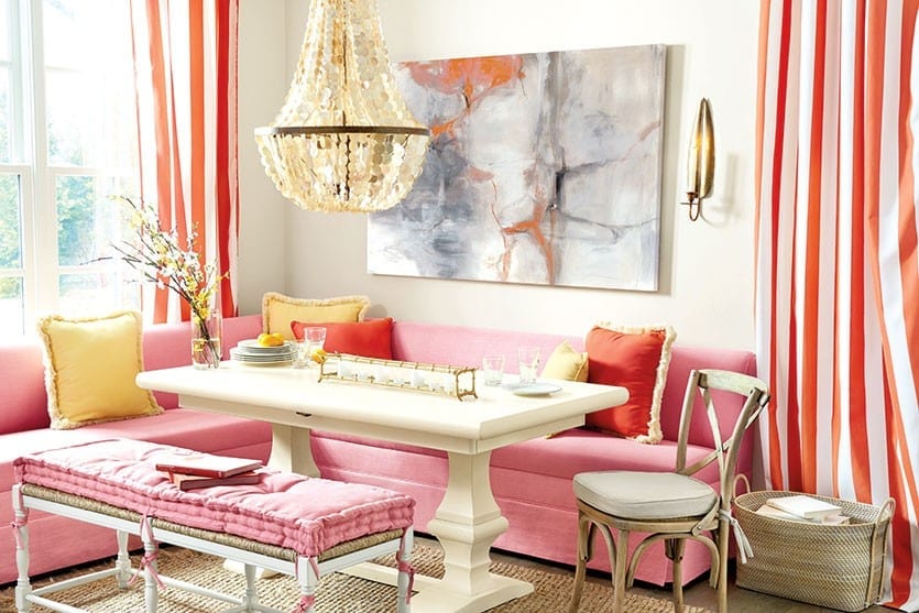 Peony pink banquette with abstract art and capiz chandelier