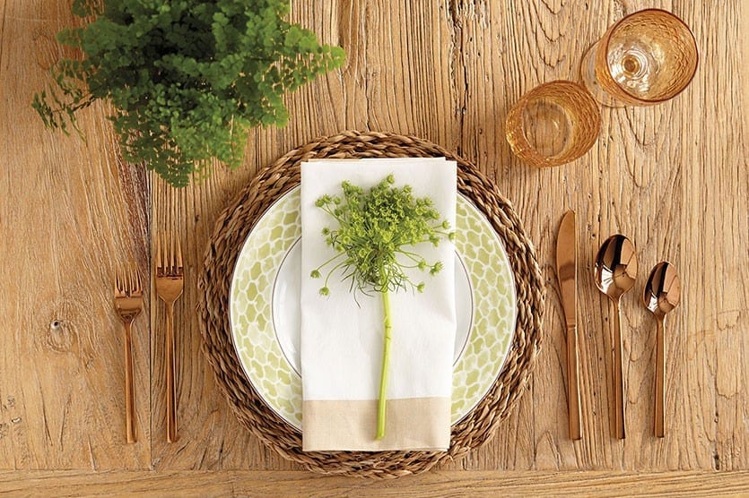 Sprigs of green flowers are fun to place at each plate for a burst of color and to echo the centerpiece of your table.