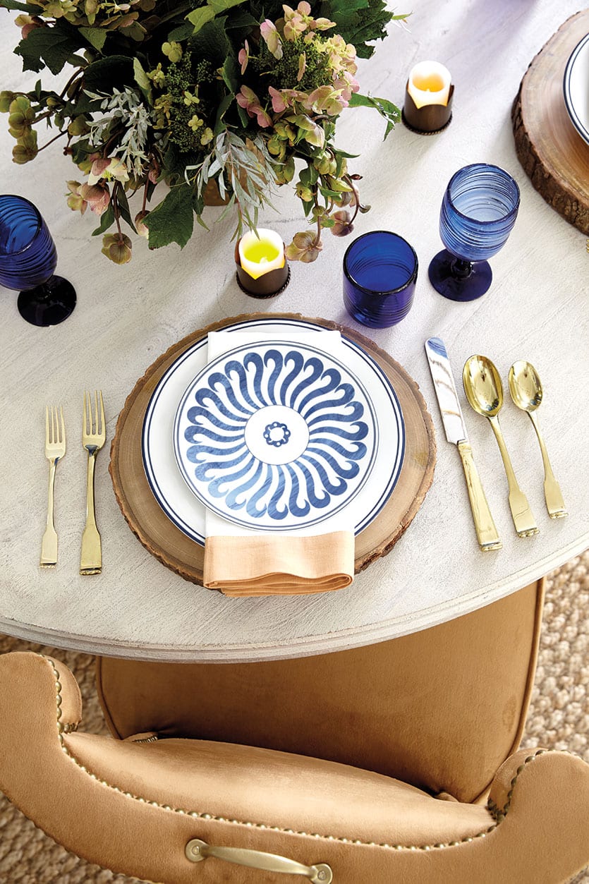 A fall-inspired table with wood chargers and blue and white dinnerware