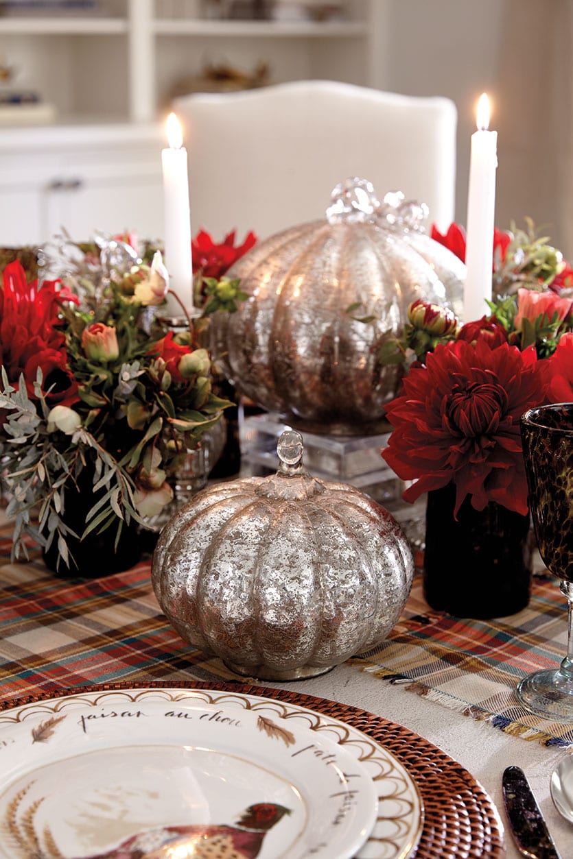 Centerpiece made of mercury glass pumpkins and small flower arrangements