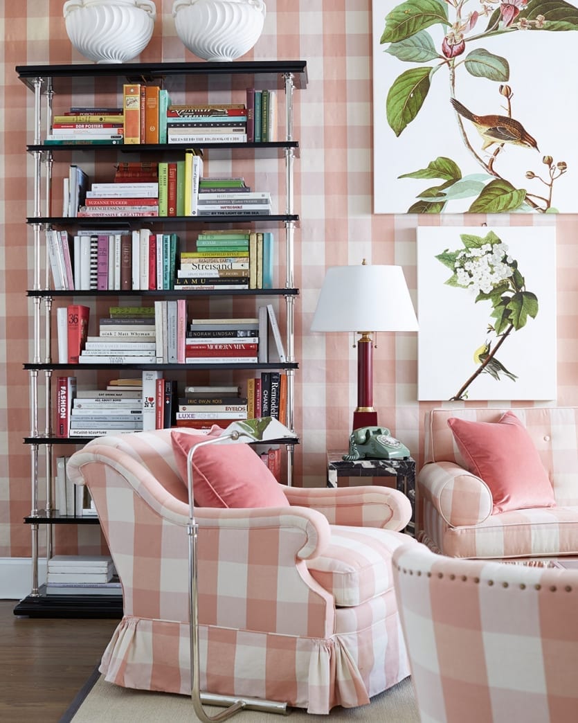 Miles Redd's Buckley Swivel Glider upholstered in pink and white buffalo check in a living room with buffalo check upholstered walls