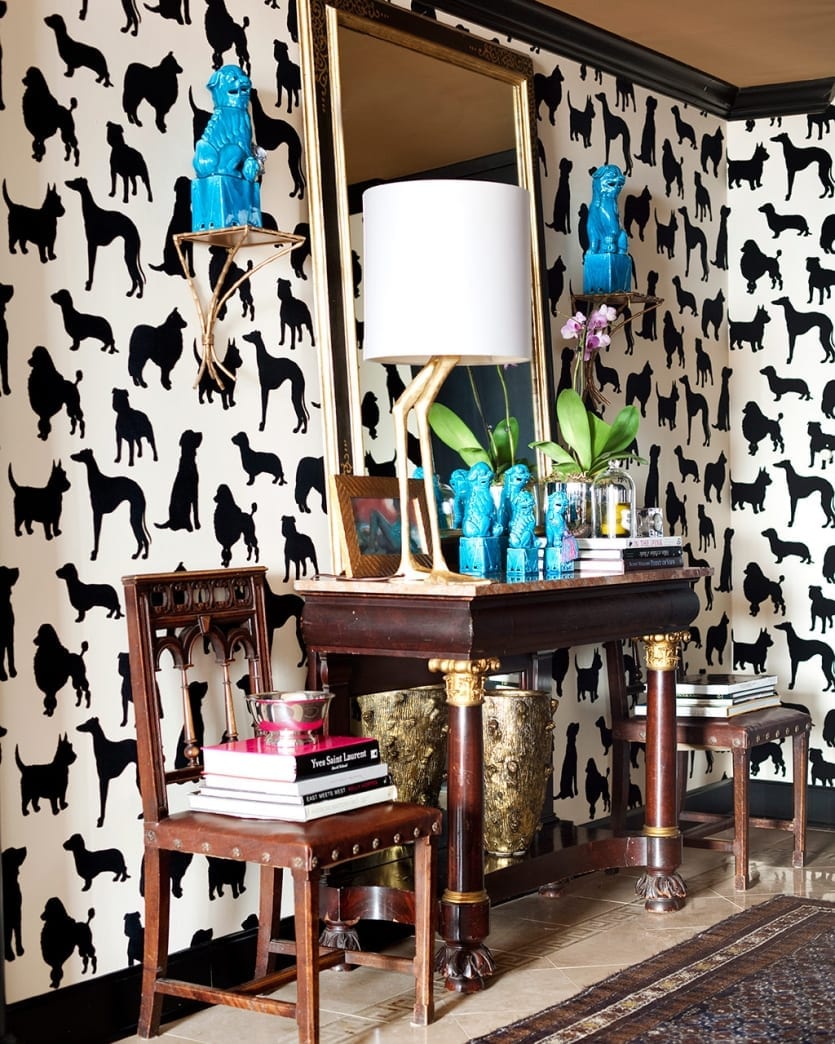 Antique console table flanked by two chairs with black and white dog wallpaper