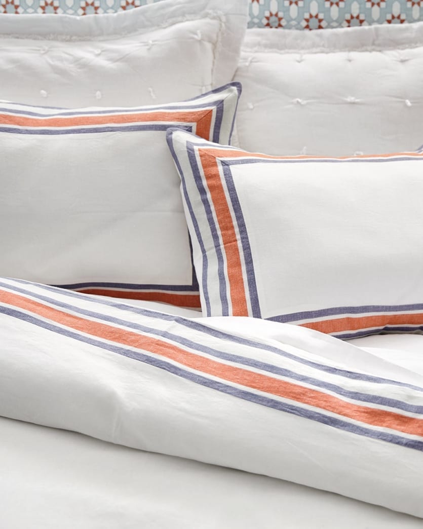 Ballard Designs Saunders Striped bedding has a blue and orange trim around the outer borders