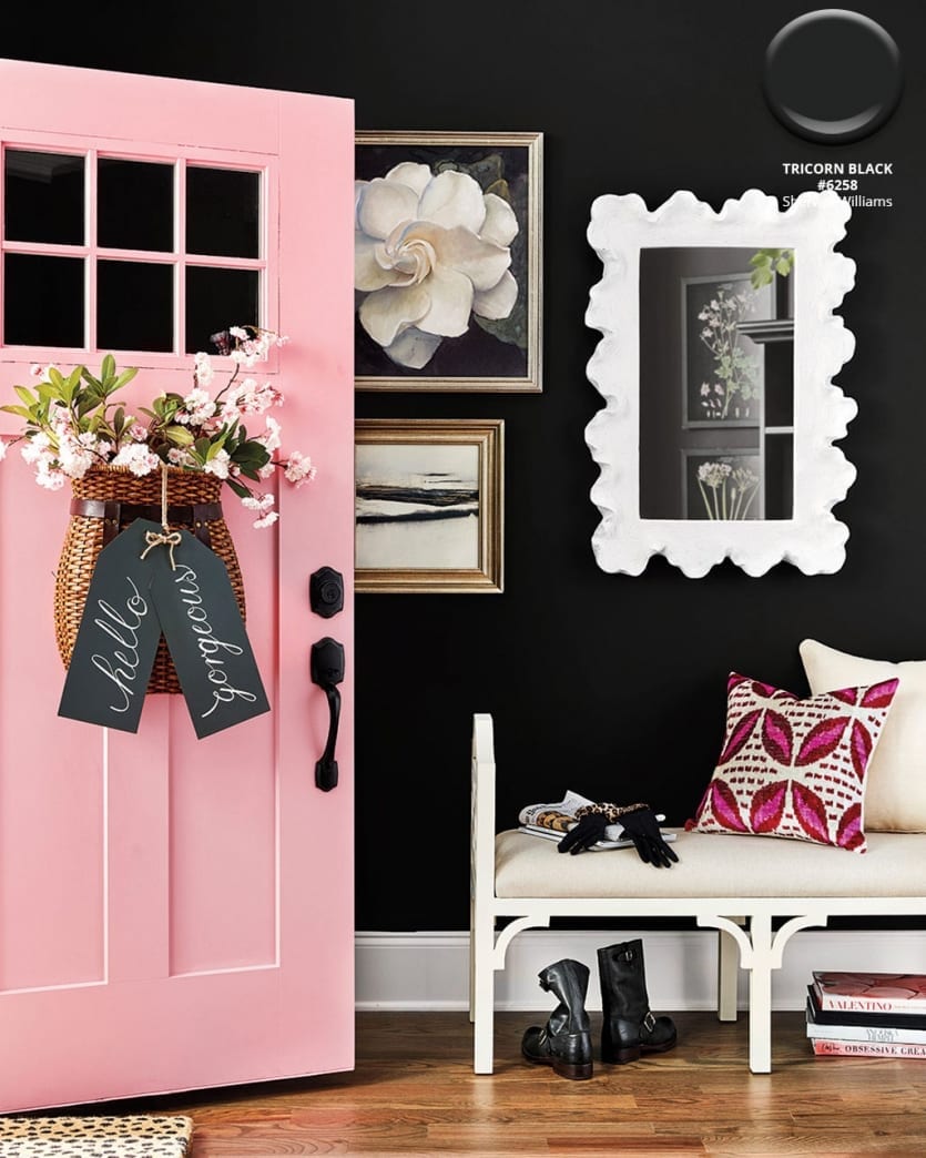 Entry space with black walls in Sherwin Williams Tricorn Black, a front door in Benjamin Moore's Romance, and white bench seat