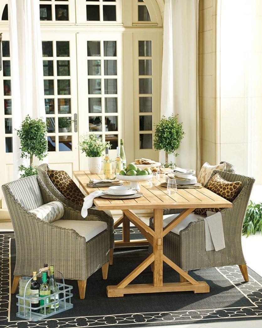 Potted topiaries on patio with teak dining table and woven chairs | Ballard Designs