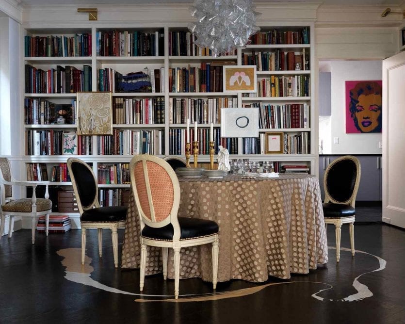 Dining room designed by Katie Lydon with large skirted table and bookcases