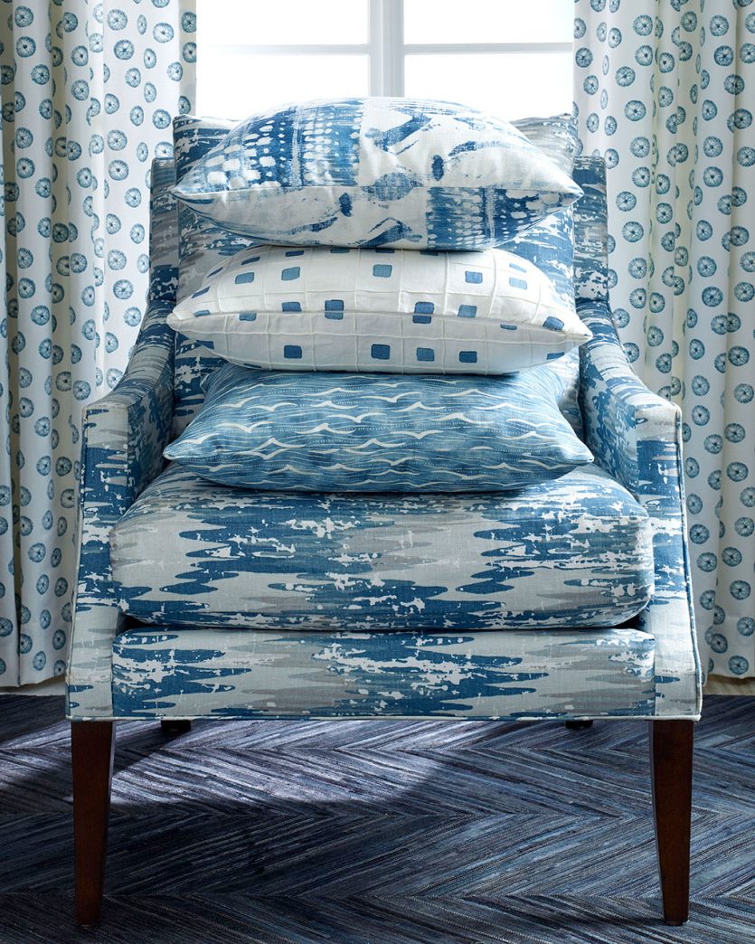 Blue chair in Kravet fabric with stack of blue patterned pillows