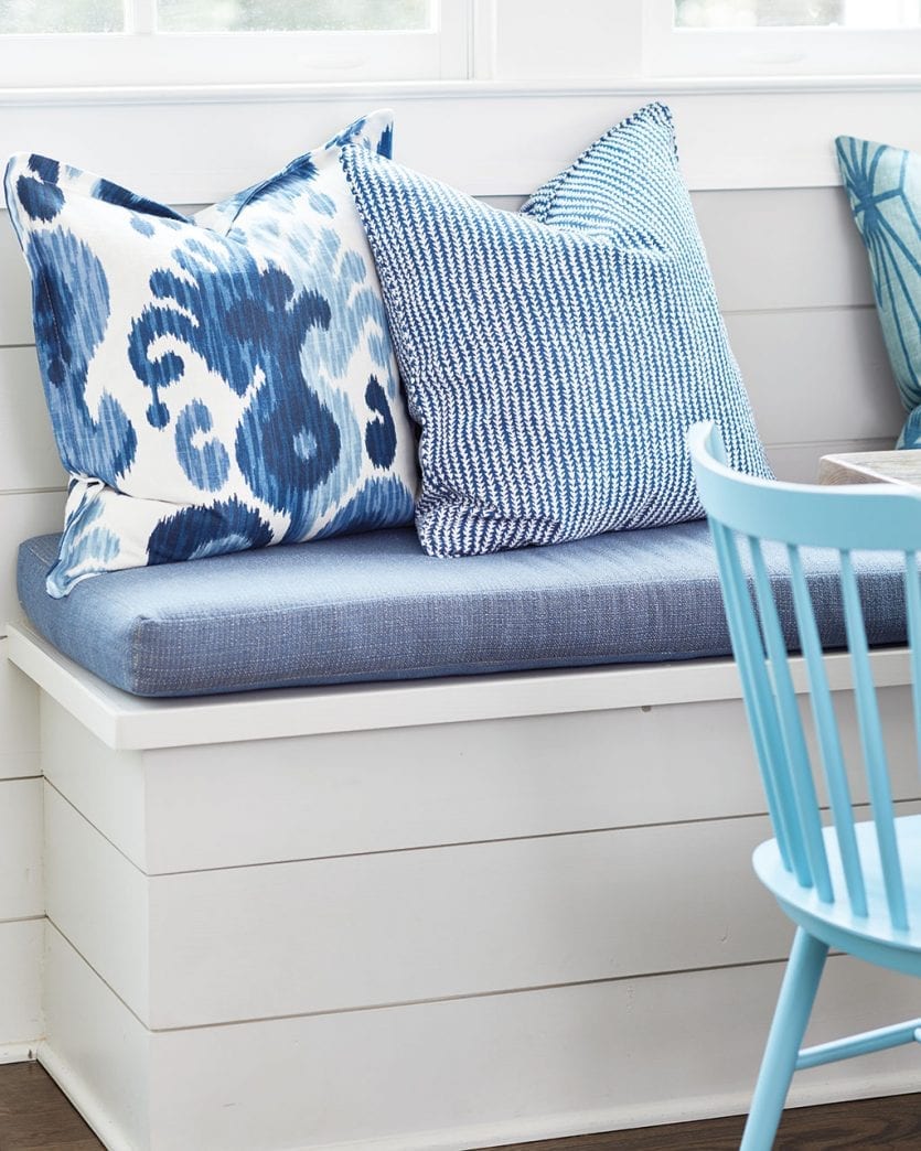 Custom pillows in blue and white patterns on breakfast banquette