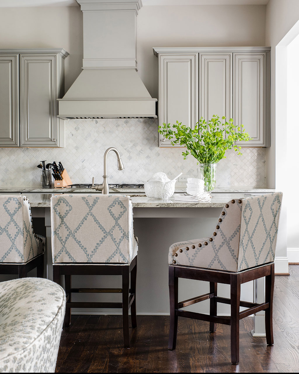 Kitchen with upholstered barstools designed by Cheryl Luckett