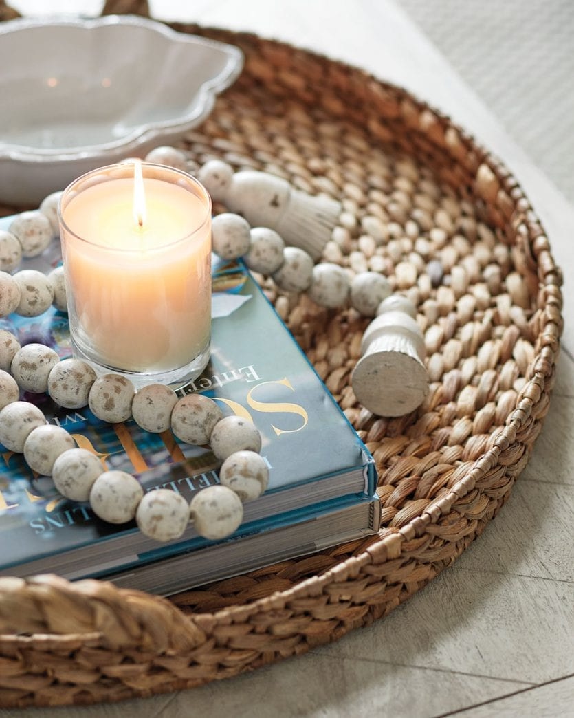 Candle and style books on coffee table in tray