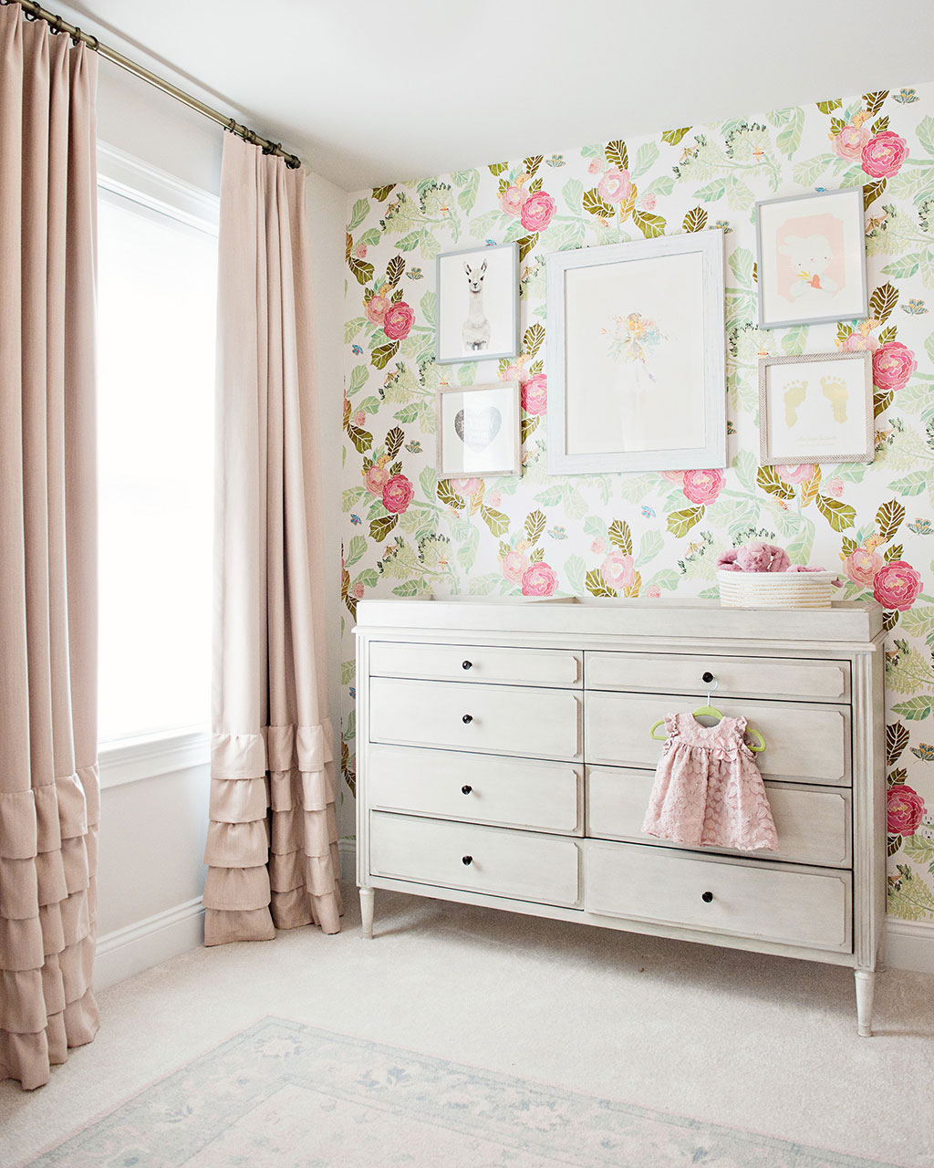 Pink baby nursery with wallpaper accent wall designed by Kimberly Barr