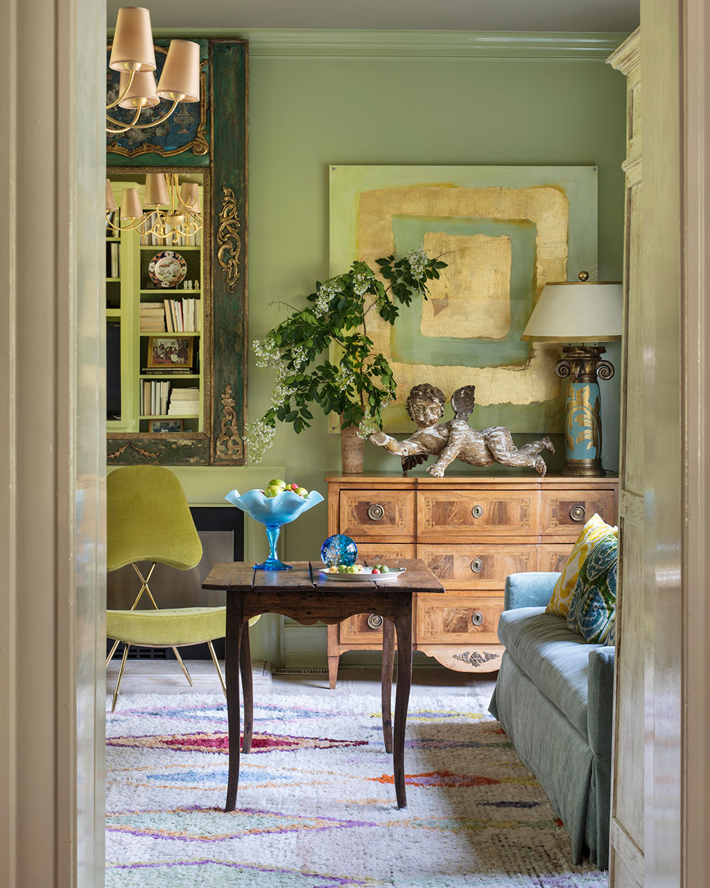 Green living room with antique furniture and modern touches