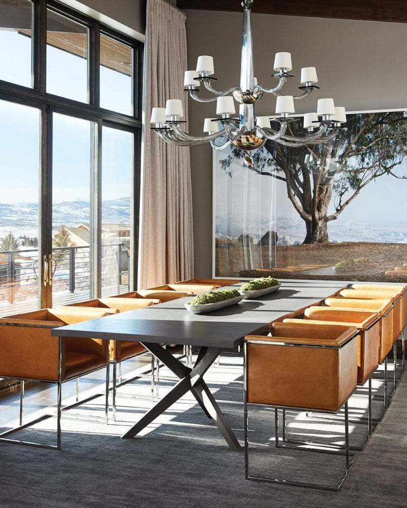 Large dining room with modern leather chairs and a traditional chandelier