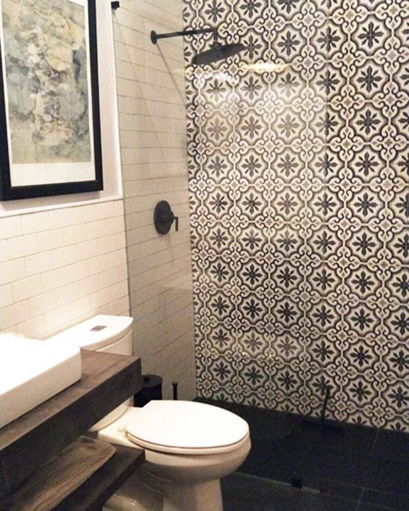 Skye's bathroom after her renovation with cement tile on the wall and black floors