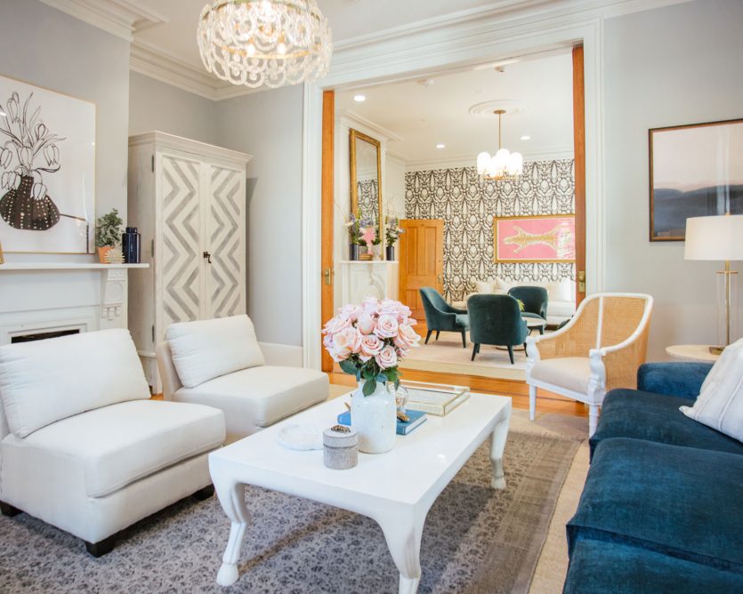 Living room from the Alpha Phi sorority house at the University of Georgia with velvet blue sofa and white side chairs