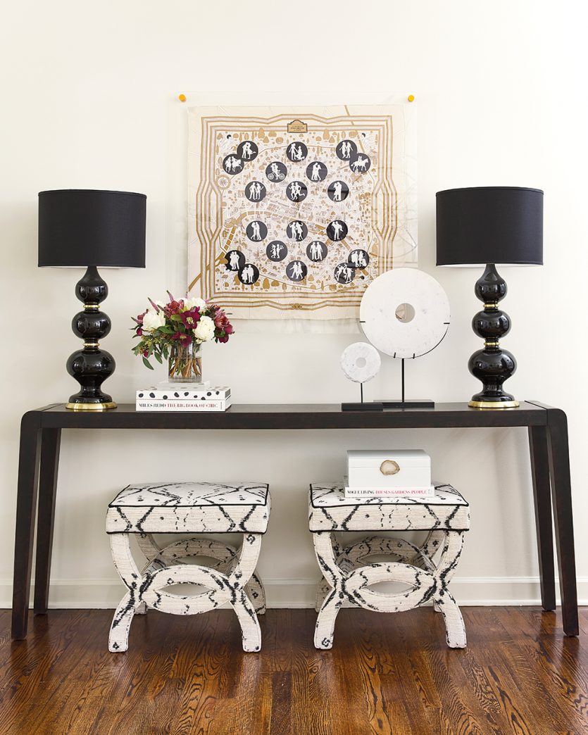 Console table with black lamps and framed Hermes scarf