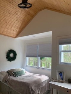 White bedroom with wooden plank pitched ceiling