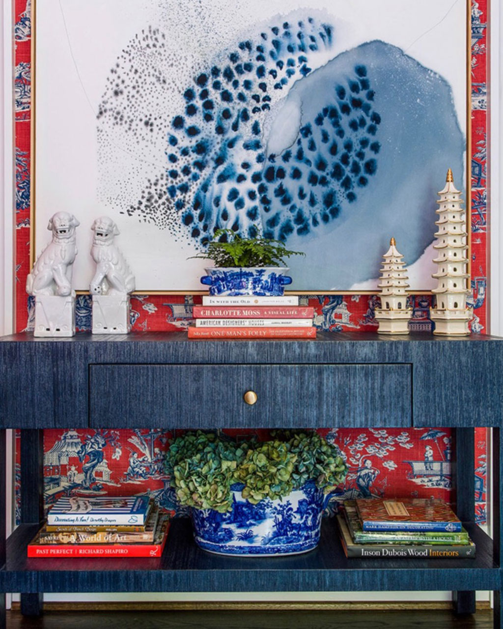 Console table in front of red and blue toile wallpaper, designed by Jena Salmon