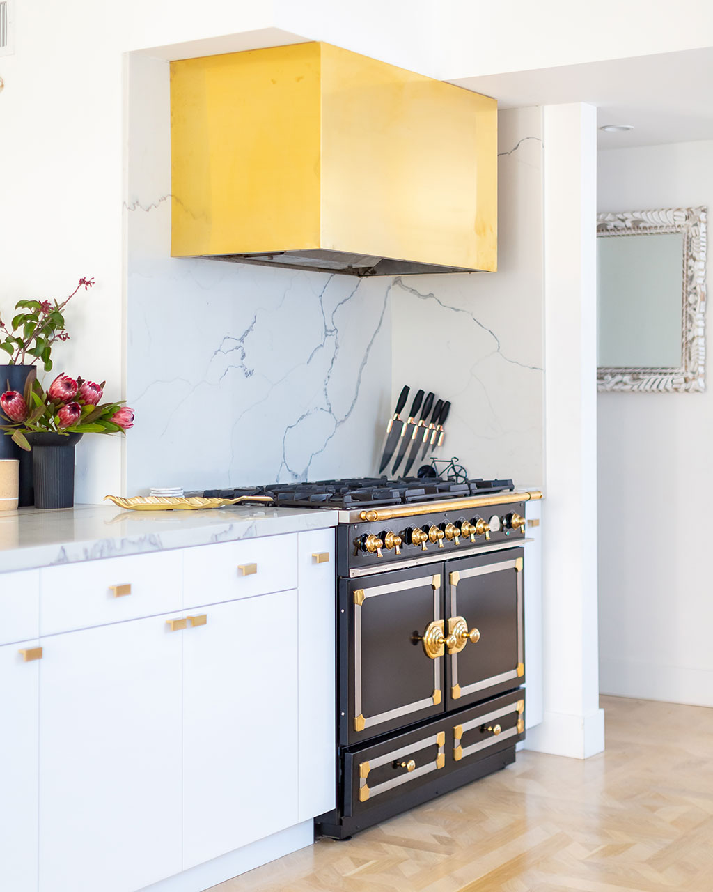 White kitchen with brass oven hood, designed by Breegan Jane