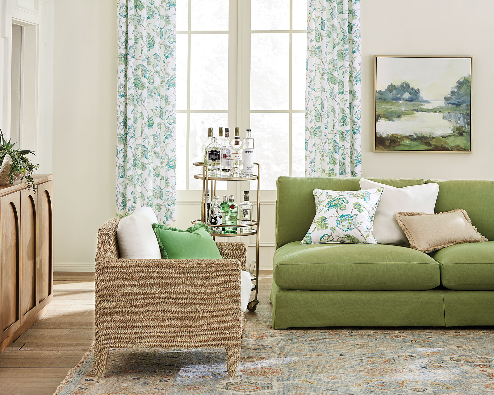 Living room with green armless sofa and coordinated curtains and pillows