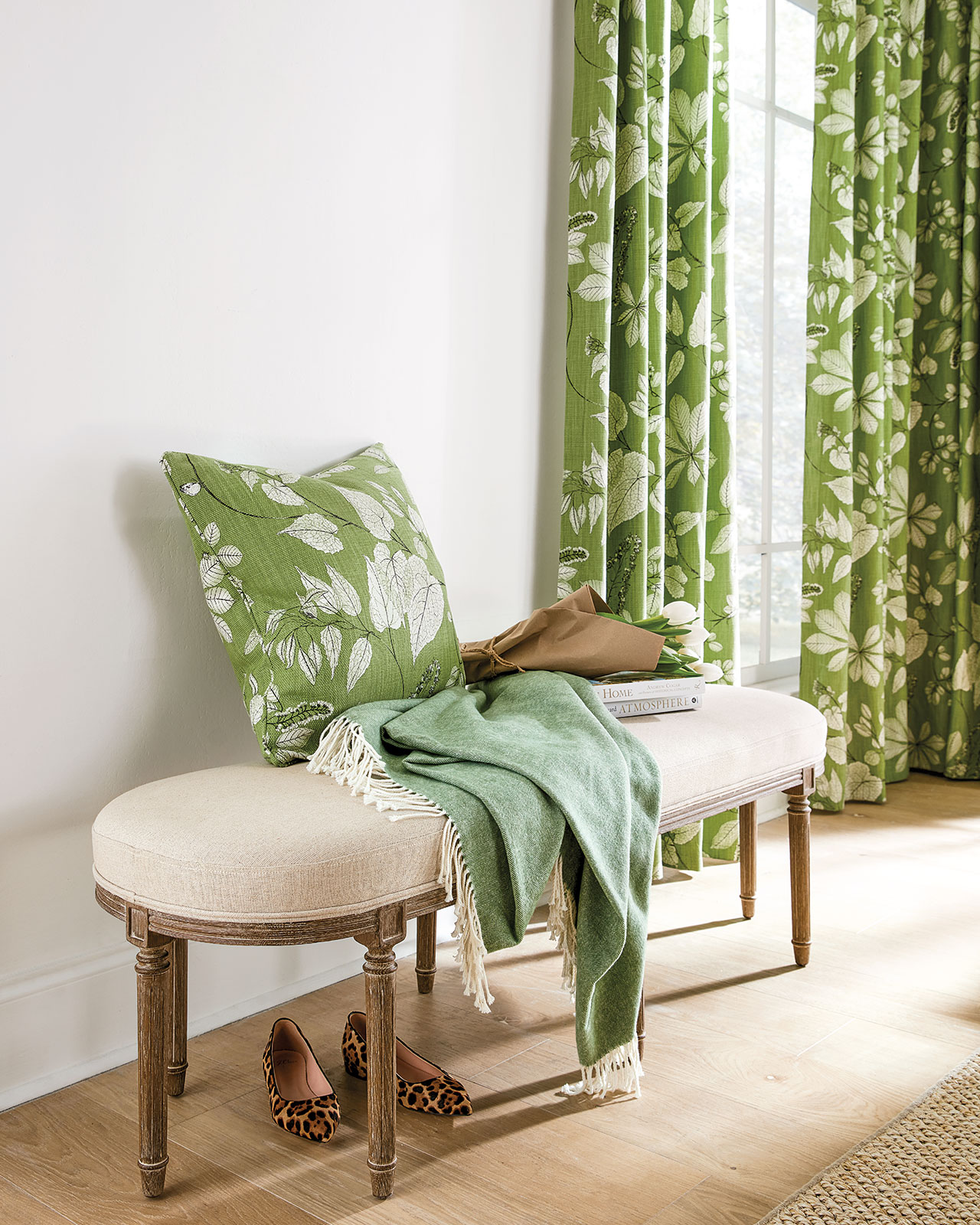 Green and white floral fabric on curtain panels and a pillow