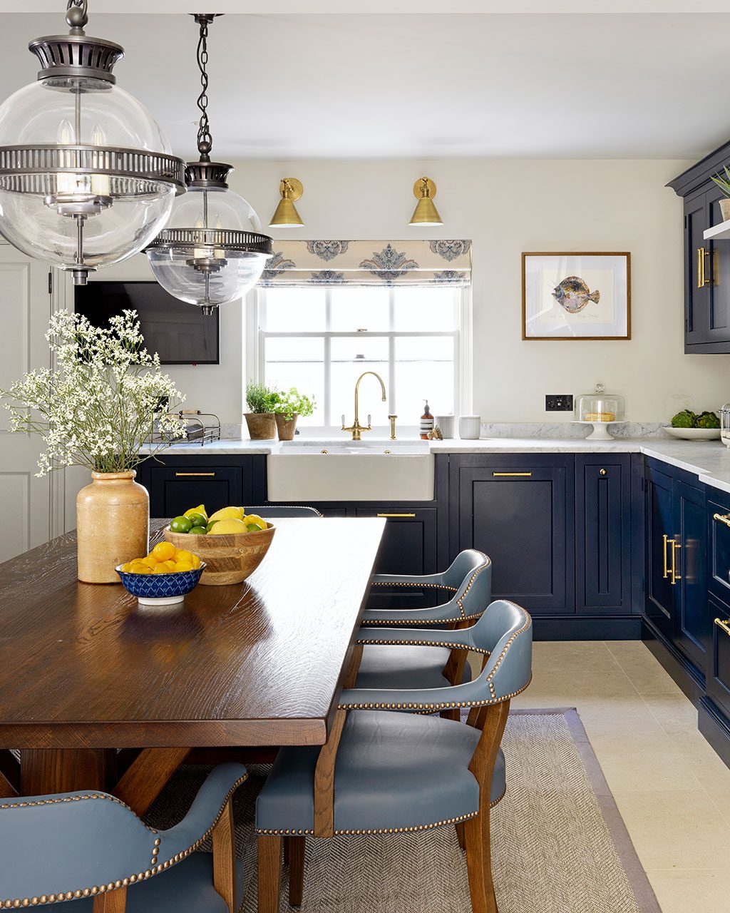 English kitchen with navy cabinets and a dining table in the center